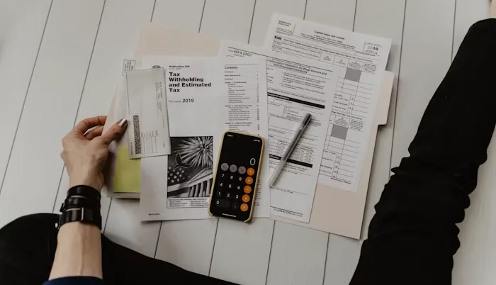 Tax forms and a calculator on a desk, an illustration of tax preparation