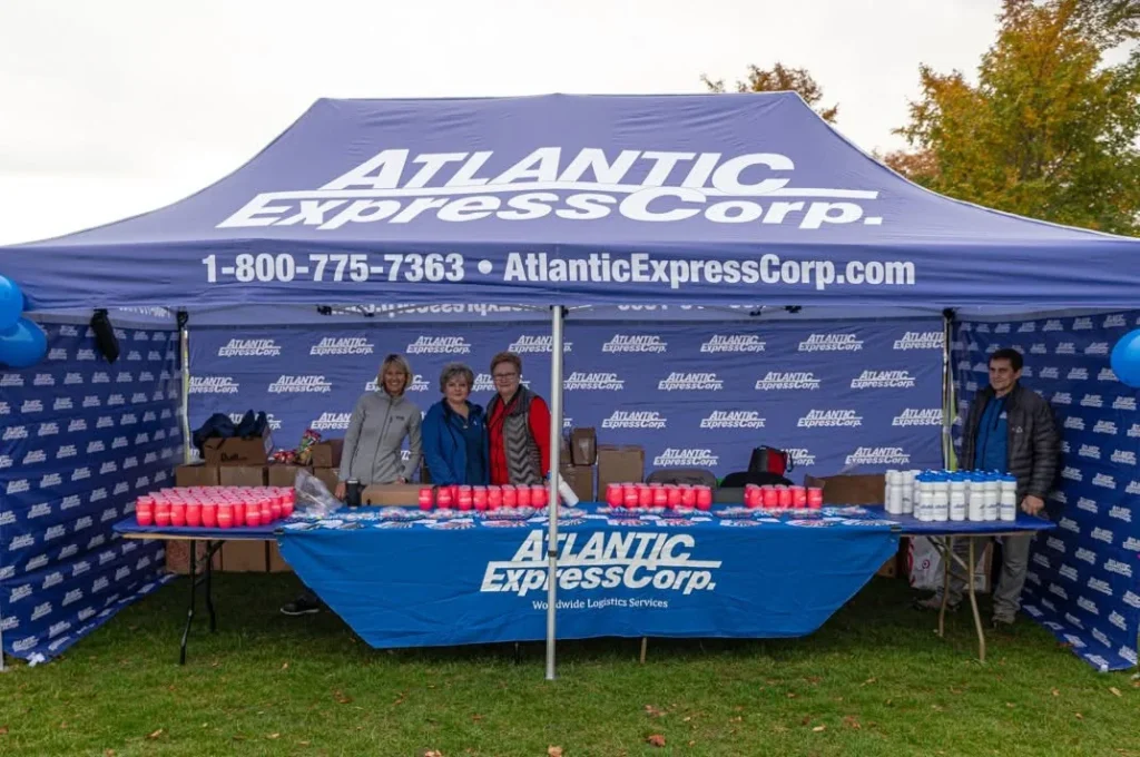 Atlantic Express branded canopy and staff at an outdoor event