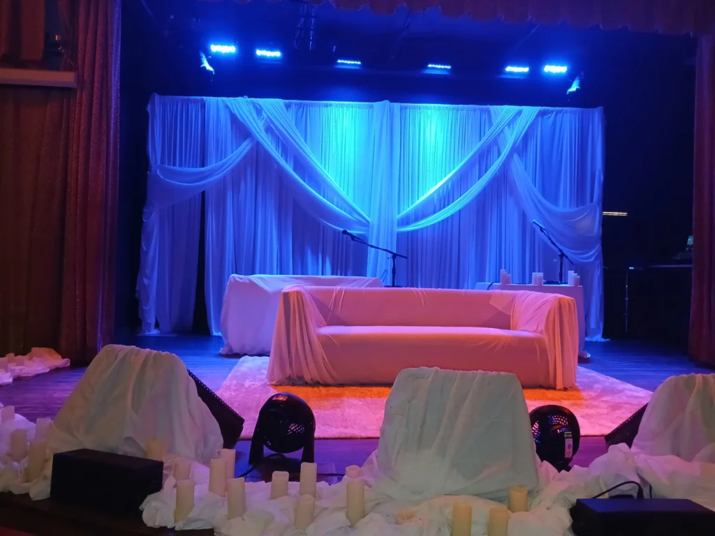 Event backdrop with blue lighting shown by Fiesta Party Rental