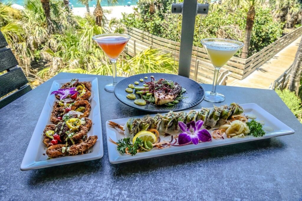 Sushi sharing platters and cocktails at an outdoor table; Fins at Sharky's gallery