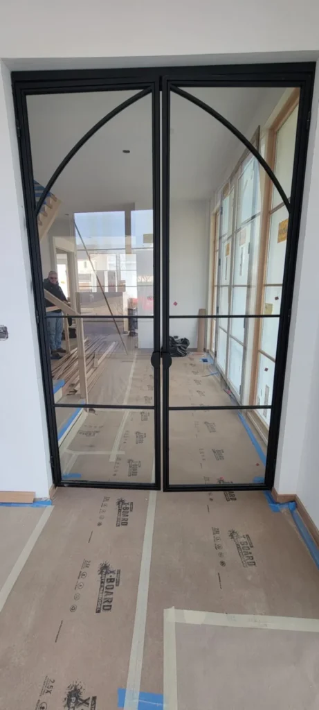 Black steel-framed glass door with an arched design in the JG Welding gallery
