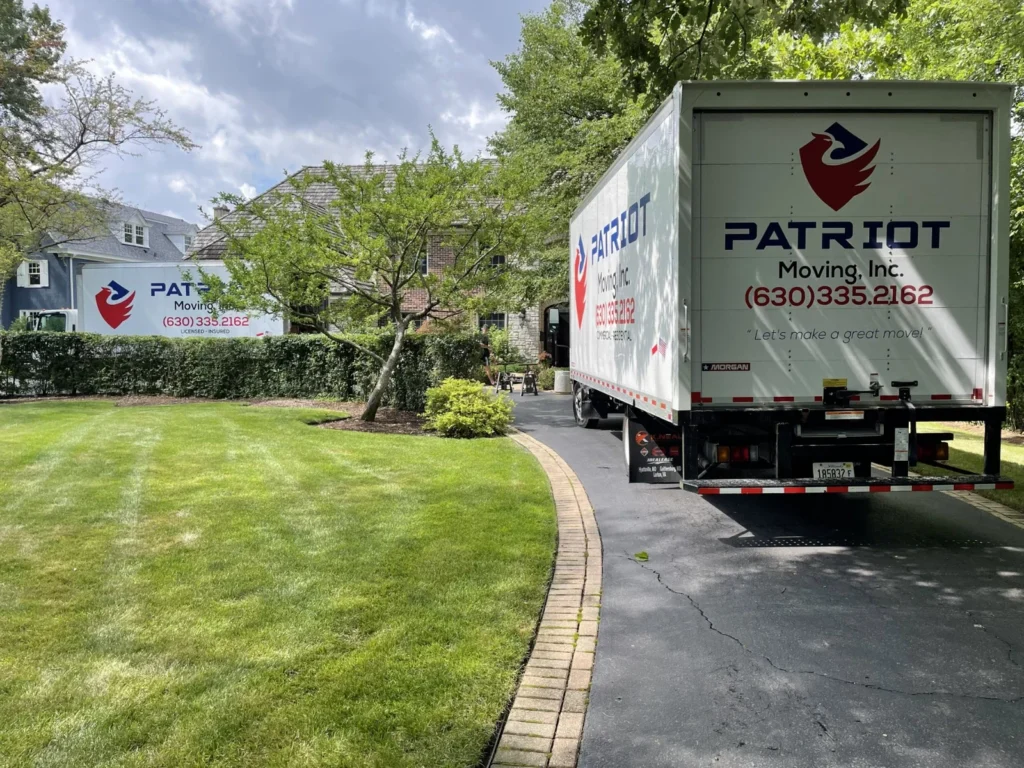 Patriot Moving trucks beside a residential driveway