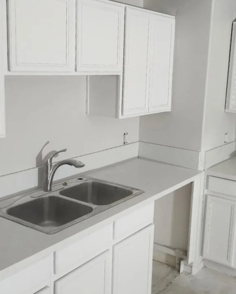 White kitchen cabinets and countertop shown by Picasso AMK