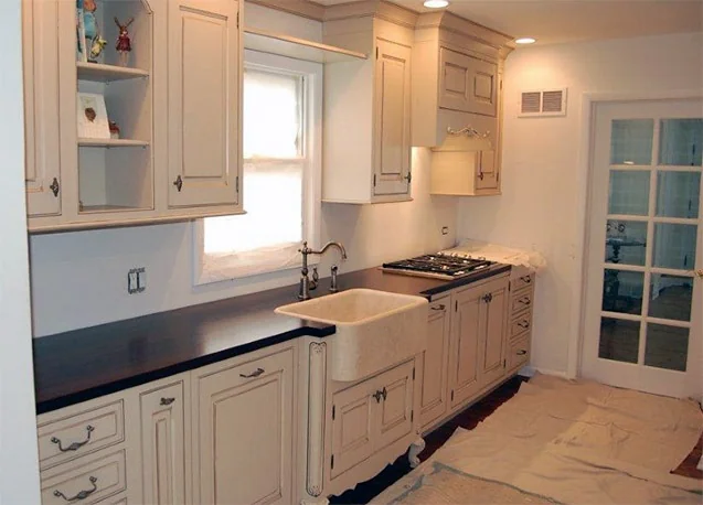 White kitchen cabinets and cooking area — Profile Remodeling