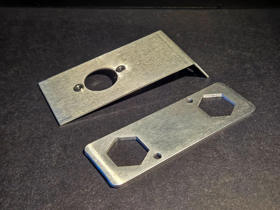 Cut metal plates with shaped openings from Quad-Metal Company