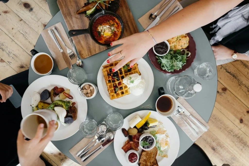 People sharing breakfast dishes at a table