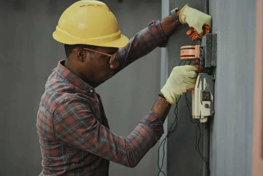 Worker wearing a hard hat working on electrical equipment