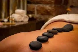 Promotional close-up of hot stones placed on a back