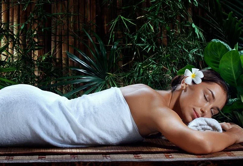 Promotional image of a woman resting on a massage table