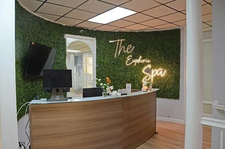 Curved wooden reception desk and green feature wall