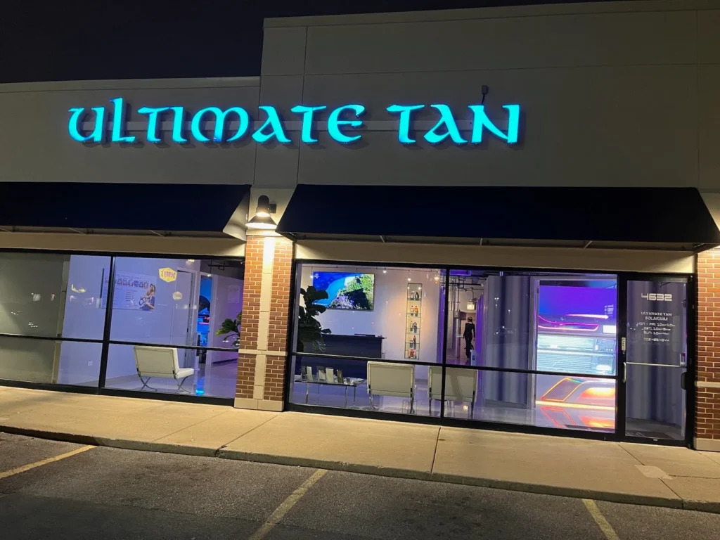 Ultimate Tan illuminated storefront at night